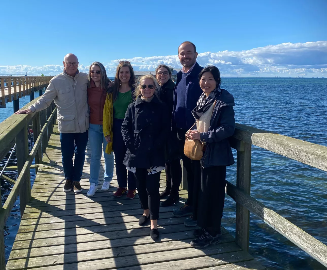 Picture of Urological Cancer groups team members standing on a bridge with ocean view in the background.