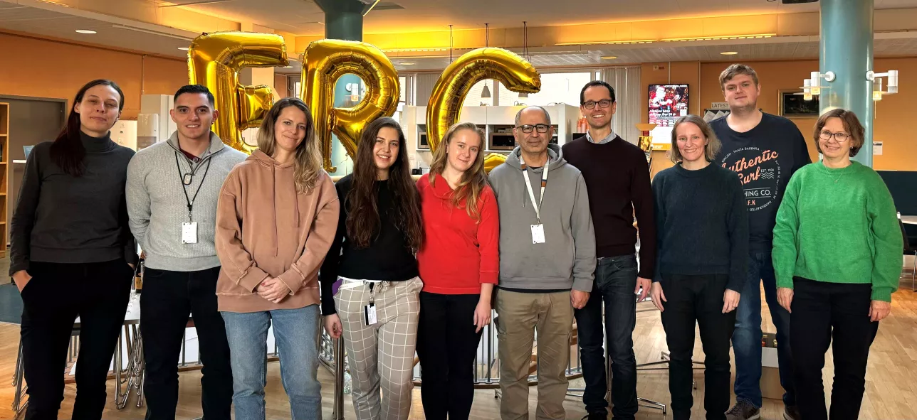 Picture of Bexell Lab group in front of ERC letters in golden helium balloons.